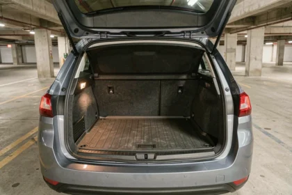 Volume du coffre de la Peugeot 308 SW phase 2 ouvert vu de l'arrière dans un parking urbain